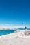 A view to Mediterranean sea, a lighthouse with breakwaters, fish