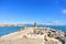 A view to Mediterranean sea, a lighthouse with breakwaters, fishing rods of locals and Torremolinos at the background