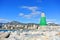 A view to Mediterranean sea, a lighthouse with breakwaters and hotels at the background from a pier at Benalmadena