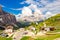 View to Passo Selva di Val Gardena whith Cappella di San Maurizio white chapel, Hotel and parking car with mountains