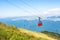 A view to red open cableway cabin over the top of the mountain a