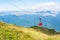 A view to red open cableway cabin over the top of the mountain a