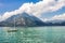 View to sailboat anchored in harbor the village of Varenna on Lake Como. Scenic landscape on background alps mountains, trees and