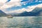 View to sailboat anchored in harbor the village of Varenna on Lake Como. Scenic landscape on background alps mountains, trees and
