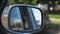 View to side mirror of old retro car with blurred city at background. Vintage automobile driving at the city street on
