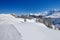 View to Skiers on the ski slopes and Swiss Alps covered by fresh