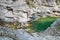 View to small clean calm mountain river, flowing among crags.