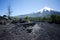 View to snowcaped peak of  Osorno Volcano from foothill desert covered with black volcanic ash