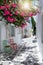 View to the typical small alleys with white houses and colorful flowers at the cycladic town of Parikia, Paros