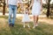 View on toddler. mother, father hold hands daughter enjoy nature and walk in the summer park. Young family spending time together