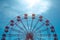 A view of the top half of a vintage Ferris Wheel fairground ride with blue sky background and copy space