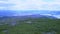 A view from the top of a hill on a wide river, blue skyline and purple forest