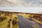 View from top of Knocknarea hill on Atlantic ocean. Winter season, snow falling on a grass and walking path. Grey cloudy sky.