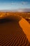 View from top of Namibian dune across foggy desert to dunes ridge