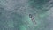 The view from the top. Scuba diver swims in the sea. A man in an underwater suit dives into the water and hunts for fish