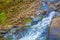 View from the top of the waterfall falling down, forest landscape with a waterfall, where begins the descent to water.