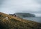 View Towards Lighthouse on the island of Mykines Holmur, Faroe Islandson a cloudy day with view towards Atlantic Ocean.