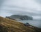 View Towards Lighthouse on the island of Mykines Holmur, Faroe Islandson a cloudy day with view towards Atlantic Ocean.