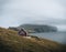 View Towards Lighthouse on the island of Mykines Holmur, Faroe Islandson a cloudy day with view towards Atlantic Ocean.