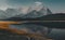 View towards mountains and lake with reflection and tree in Lower Kananaskis Lake of Peter Lougheed Provincial Park