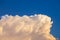 View of towering cumulonimbus thunderstorm cloud with blue sky i