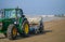 View on tractor cleaning sand in a beach