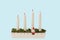 View of traditional advent candlestick with one lighted candle  symbolizing third advent isolated  on blue background