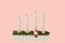 View of traditional advent candlestick with one lighted candle  symbolizing third advent isolated  on pink background