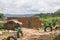 View of traditional village, thatched on roof houses and terracotta brick walls, cloudy sky as background, in Angola