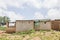 View of traditional village, zinc sheet on roof houses and terracotta brick walls, cloudy sky as background, in Angola