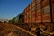 View of the train of cisterns and wagons at sunrise against the blue sky.