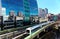 View of a train traveling on elevated rails of Taipei Metro System by a modern building of glass curtain walls on a beautiful sunn