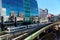 View of a train traveling on elevated rails of Taipei Metro System by a modern building of glass curtain walls on a beautiful sunn