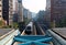 View of a train traveling on elevated rails of Taipei Metro System between office towers under cloudy  sky