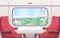 View from train window flat vector illustration. Modern railway carriage interior with comfortable red chairs and small