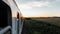 The view from the train window overlooking the wagons on the field and the orange summer sunset.