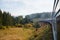 View from the train window at the sunlit village. Carpathians