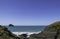 View of trebarwith strand in Cornwall, England with aquamarine crystal water and blue sky