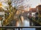 View on a treelined canal in Bruges during winter, on a sunny day