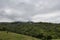 View of trees, houses, mountains and clouds.