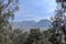 View through the trees and mountain vegetation of the crater of the active volcano Bromo and the photogenic Mount Batok in close