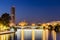 View of the Triana Bridge Bridge of Isabel II spanning the Guadalquivir River and city skyline in Seville, Spain