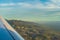 View of the tropical island of O'ahu from above over wing during golden hour