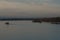 View on tug boats, barges and pushers from container terminal on the Columbia river surrounded by trees and bushes during sunset