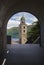 View through the tunnel to the church bell tower, lake and mountains.