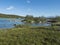 View of turquoise blue wild Vuojatadno river wih distant figure of fisherman in the water. Northern landscape in Swedish