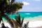 View on turquoise coastline near blue lagoon with wave breakers and white foam beyond palm trees, Portland, Jamaica