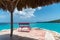 View of turquoise sea with red chair on the shoreline on the island of Curacao.