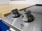 View of two control knobs on a glass stove top in a clean kitchen with wooden counter tops