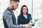 View of two employees in suits standing holding papers, preparing for performance speech before their boss, feeling